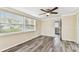 Cozy bedroom boasts wood-look flooring, a ceiling fan, and lots of natural light at 5033 Tammy Ln, Holiday, FL 34690