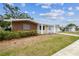 Single-story home with brick and siding, lawn, and a driveway, showcasing a simple, inviting exterior at 5033 Tammy Ln, Holiday, FL 34690