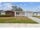 Single-story home with brick and siding, lawn, and a driveway, showcasing a simple, inviting exterior at 5033 Tammy Ln, Holiday, FL 34690