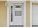 Close-up of a white front door with glass accents and sidelight, offering a welcoming entrance at 5033 Tammy Ln, Holiday, FL 34690