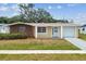 Charming single-story home with a lush front lawn, inviting entryway, and attached garage at 5033 Tammy Ln, Holiday, FL 34690
