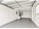 Clean garage interior featuring an epoxy floor, white walls, and practical storage solutions at 5033 Tammy Ln, Holiday, FL 34690