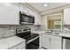 Modern kitchen features white cabinets, stainless steel appliances and mosaic backsplash at 5033 Tammy Ln, Holiday, FL 34690