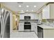 Modern kitchen with stainless steel refrigerator and appliances plus white cabinets and backsplash at 5033 Tammy Ln, Holiday, FL 34690
