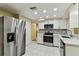 Modern kitchen featuring stainless steel appliances, white cabinets, and marble countertops at 5033 Tammy Ln, Holiday, FL 34690