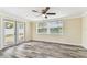Bright living room features wood-look flooring, a ceiling fan, and sliding glass doors at 5033 Tammy Ln, Holiday, FL 34690