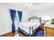 Inviting bedroom with a comfortable queen-size bed, complemented by stylish blue curtains and wood flooring at 5037 Starfish Se Dr # A, St Petersburg, FL 33705