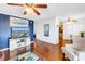 Cozy living room with a large flat-screen TV, ceiling fan, and dark wood floors at 5037 Starfish Se Dr # A, St Petersburg, FL 33705