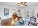 Bright living room with dark wood floors, ceiling fan, and sliding glass doors to balcony at 5037 Starfish Se Dr # A, St Petersburg, FL 33705