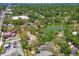 Aerial view captures a community with a green pond, tree coverage, and nearby commercial development at 5806 N 9Th St, Tampa, FL 33604