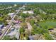 Aerial view reveals a green pond near a commercial area with streets, trees, and buildings nearby at 5806 N 9Th St, Tampa, FL 33604