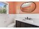 Well-lit bathroom featuring a toilet, vanity, mirror, and window with natural light at 5806 N 9Th St, Tampa, FL 33604