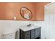 Updated bathroom features white tiling, a dark vanity, toilet, and an oval mirror at 5806 N 9Th St, Tampa, FL 33604