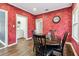 Dining room boasts a wooden table with red walls and a view leading to the laundry room and other areas at 5806 N 9Th St, Tampa, FL 33604