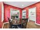 View of the dining room with red textured walls and a wooden table set adjacent to the kitchen and laundry room at 5806 N 9Th St, Tampa, FL 33604