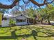 Charming home with a screened porch, surrounded by lush landscaping and mature trees at 5806 N 9Th St, Tampa, FL 33604