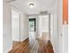 Hallway with hardwood floors, doorways, and natural light, leading to various rooms at 5806 N 9Th St, Tampa, FL 33604