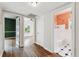 Hallway showcasing hardwood floors, multiple doorways, and natural light, offering access to different spaces at 5806 N 9Th St, Tampa, FL 33604