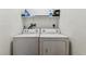 Functional laundry area featuring a washer, dryer, and shelving for storage at 5806 N 9Th St, Tampa, FL 33604