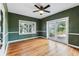 This living room features hardwood floors, modern ceiling fan, and large windows for an airy space at 5806 N 9Th St, Tampa, FL 33604