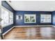 Spacious living room with dark-stained hardwood floors, blue walls, and ample natural light at 5806 N 9Th St, Tampa, FL 33604