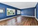Bright living room featuring hardwood floors, stylish blue walls, and recessed lighting at 5806 N 9Th St, Tampa, FL 33604