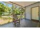 Charming screened-in porch with a comfortable chair and a view of the lush surroundings at 5806 N 9Th St, Tampa, FL 33604