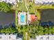 Aerial view showcasing the pool, pond, surrounding foliage and roofs of complex at 5980 Terrace Park N Dr # 214, St Petersburg, FL 33709