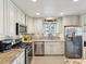 Bright kitchen featuring stainless steel appliances, granite counters, and white cabinets for a clean and modern design at 5980 Terrace Park N Dr # 214, St Petersburg, FL 33709
