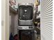 Efficient laundry area features a stacked washer and dryer, with shelving for organized storage at 5980 Terrace Park N Dr # 214, St Petersburg, FL 33709