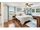 Comfortable main bedroom featuring hardwood floors, a ceiling fan, and ample natural light from surrounding windows at 5980 Terrace Park N Dr # 214, St Petersburg, FL 33709