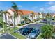 Low angle of condominium building with beige exterior, terra cotta roof, palm trees and convenient parking at 6171 Bahia Del Mar Blvd # 216, St Petersburg, FL 33715