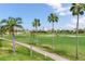 A view of a lush green golf course with scattered palm trees and a paved pathway at 6171 Bahia Del Mar Blvd # 216, St Petersburg, FL 33715