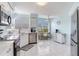 Bright kitchen features white cabinets, stainless steel appliances, and dining area with natural light at 6171 Bahia Del Mar Blvd # 216, St Petersburg, FL 33715