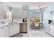 Bright kitchen features white cabinets, stainless steel appliances, and dining area with natural light at 6171 Bahia Del Mar Blvd # 216, St Petersburg, FL 33715