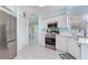 Bright kitchen with white cabinets, stainless steel appliances, and white tiled flooring at 6171 Bahia Del Mar Blvd # 216, St Petersburg, FL 33715