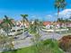 Wide street scene with lush landscaping, sidewalks and beautiful tropical palm trees and community pool at 6171 Bahia Del Mar Blvd # 216, St Petersburg, FL 33715
