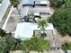 Aerial view of home with metal roof, well-manicured lawn, and mature trees at 627 64Th S Ave, St Petersburg, FL 33705