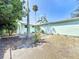 Spacious backyard features a mix of green trees, plants and rock details with a light blue house at 627 64Th S Ave, St Petersburg, FL 33705
