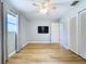 View of bedroom features ceiling fan, wood floors, neutral walls, TV, and closet at 627 64Th S Ave, St Petersburg, FL 33705