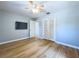 View of bedroom featuring ceiling fan, wood floors, neutral walls, TV, and closet at 627 64Th S Ave, St Petersburg, FL 33705