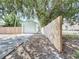 Long driveway leads to a backyard garage with a privacy fence on one side at 627 64Th S Ave, St Petersburg, FL 33705