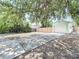 View of the garage and surrounding backyard area, featuring a long driveway and wooden fence at 627 64Th S Ave, St Petersburg, FL 33705