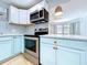 A modern kitchen featuring stainless steel appliances and light blue cabinets at 627 64Th S Ave, St Petersburg, FL 33705