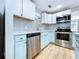 View of the kitchen with stainless steel appliances and light blue cabinetry at 627 64Th S Ave, St Petersburg, FL 33705
