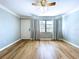 Spacious living room with hardwood floors, a ceiling fan, a large window, and fresh paint at 627 64Th S Ave, St Petersburg, FL 33705