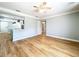 View of a spacious living room with hardwood floors, fan and a view to the kitchen at 627 64Th S Ave, St Petersburg, FL 33705
