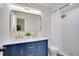 Modern bathroom with double sinks, blue vanity, stylish gold fixtures and shower at 8277 82Nd N Ave, Largo, FL 33777
