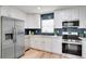 Modern kitchen with stainless steel appliances, white cabinetry, and blue subway tile backsplash at 8277 82Nd N Ave, Largo, FL 33777