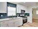 Charming kitchen with blue subway tile backsplash, stainless steel appliances, and modern white cabinetry at 8277 82Nd N Ave, Largo, FL 33777